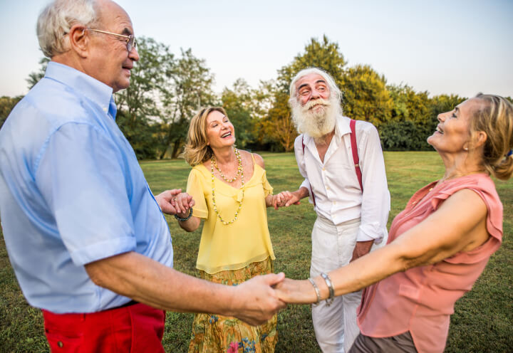 Elderly Friends Holding Hands in Circle Outdoors at Independent Living Facility Elderly Friends Holding Hands in Circle Outdoors at Independent Living Facility