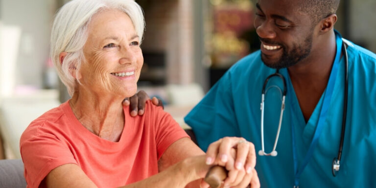Female Nurse Supporting Elderly Woman With Walking Cane in Assisted Living